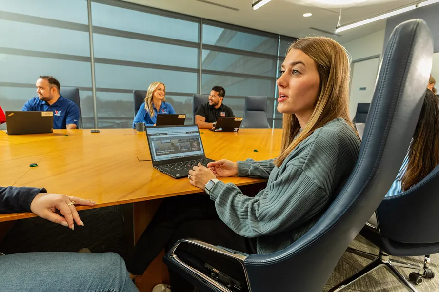 A diverse group of Valvoline employees is attending a meeting around a conference table