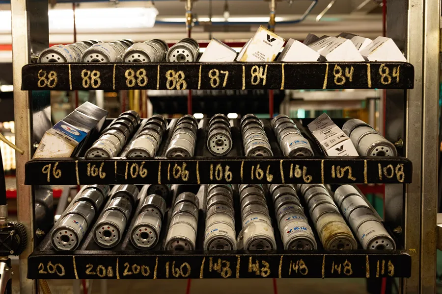 An organized and well-stocked rack of various oil filters in a **Valvoline service center**.