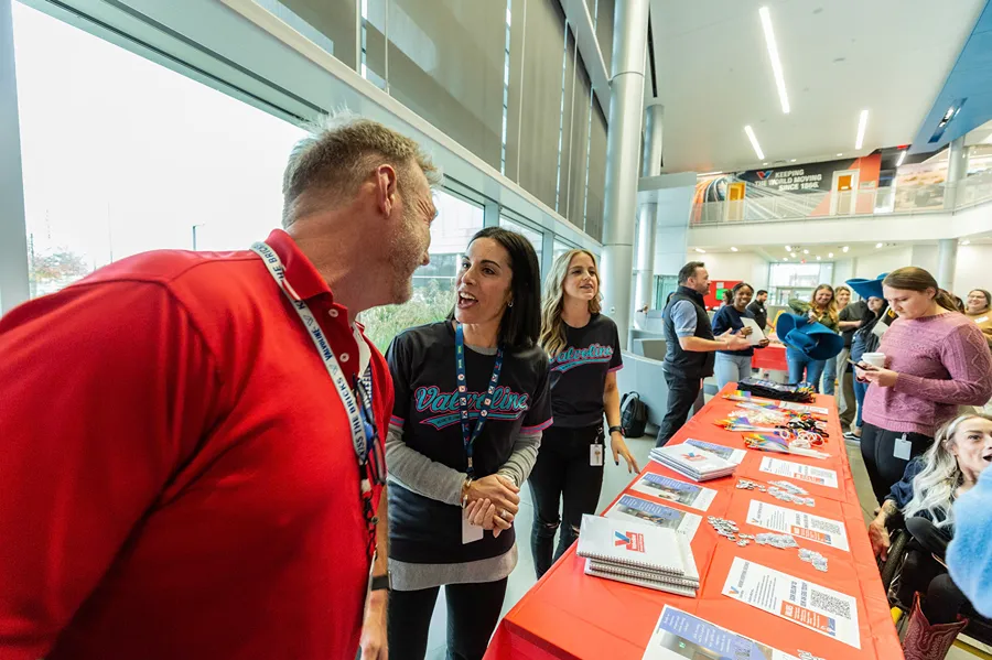 Valvoline employees are interacting with colleagues at a brightly lit corporate event table.