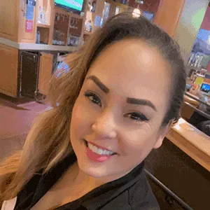 Applebee's team member wear blue shirt smiling in uniform
