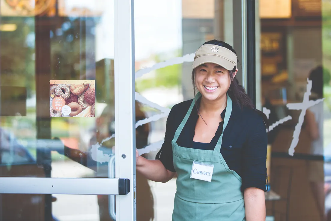 Four smiling team members in a bakery setting