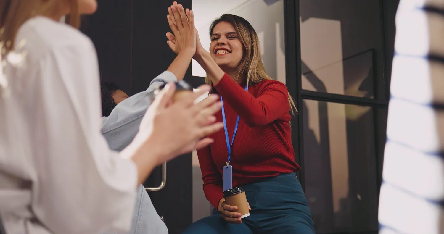 Three women celebrating a success with a high five