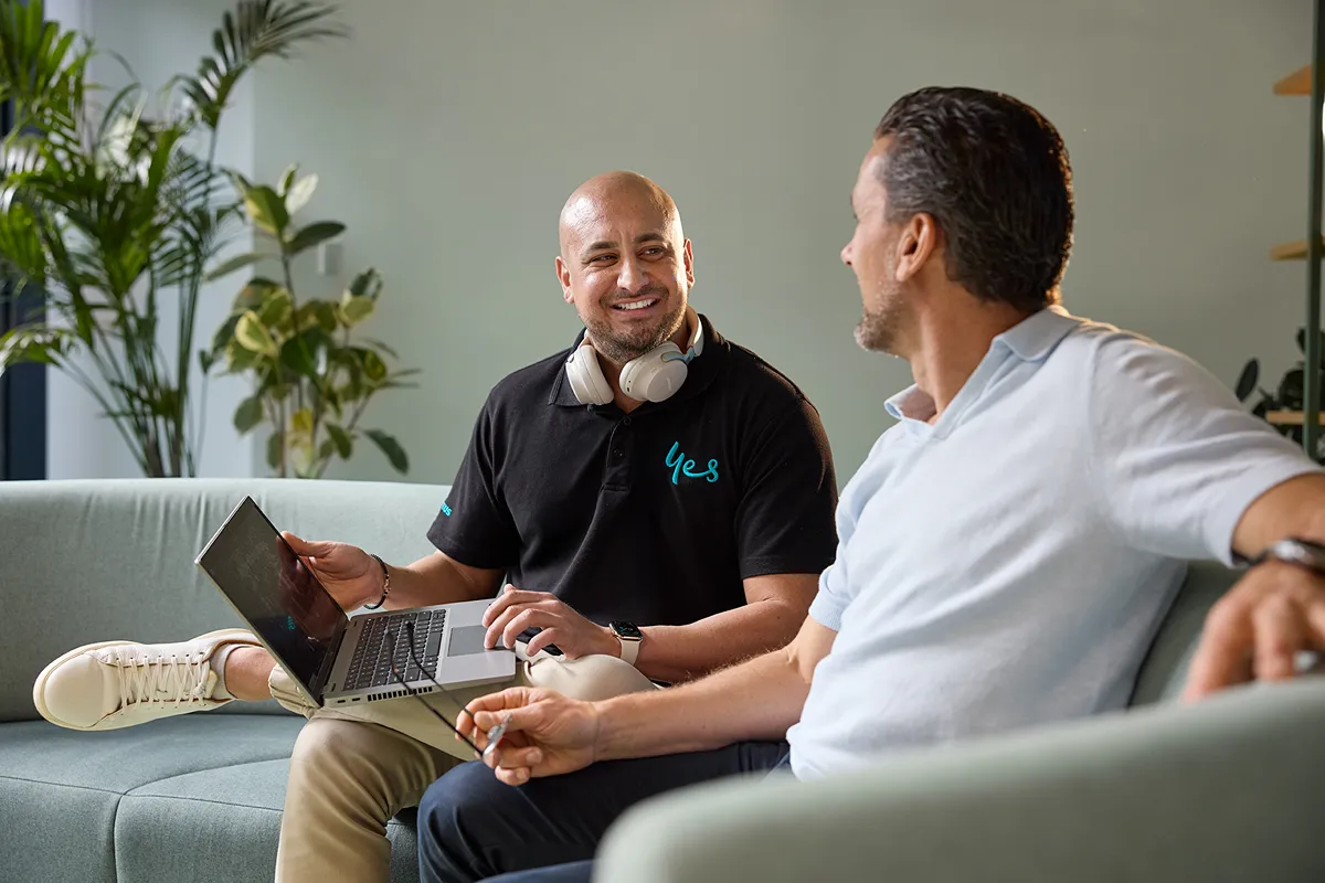 Two people sitting on sofa and talking