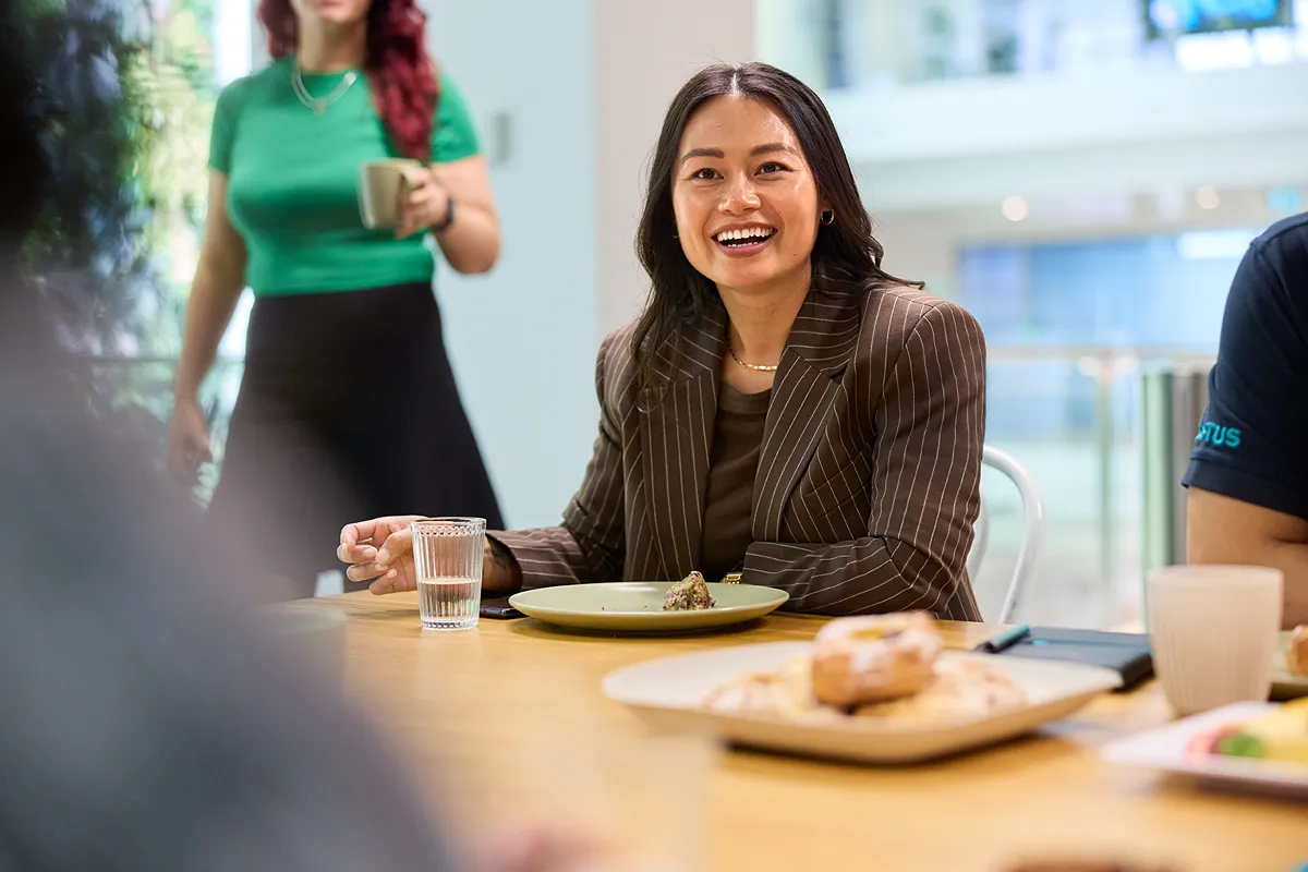 2 people adding sticky notes to the board