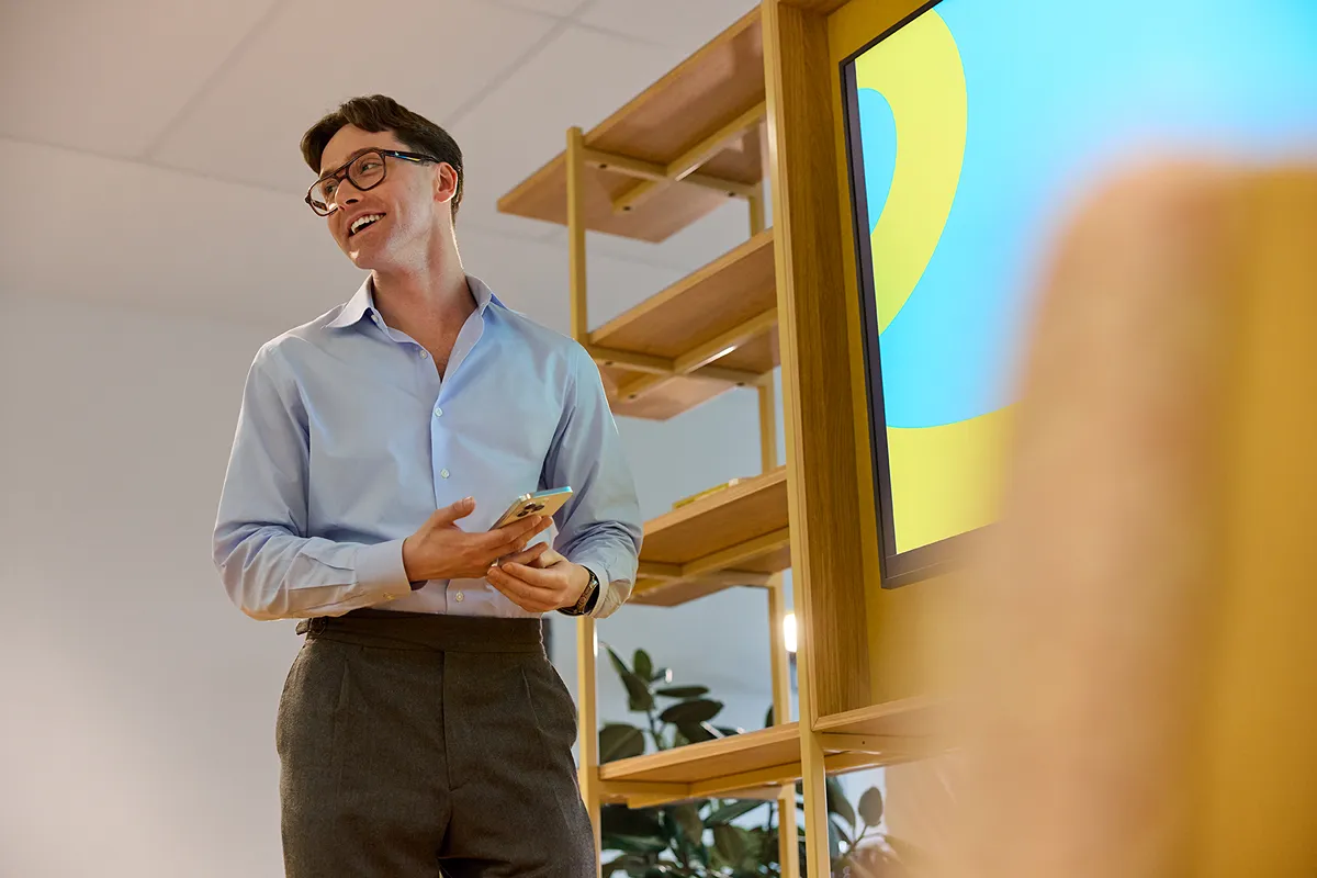 Two colleagues collaborating and smiling at a computer workstation