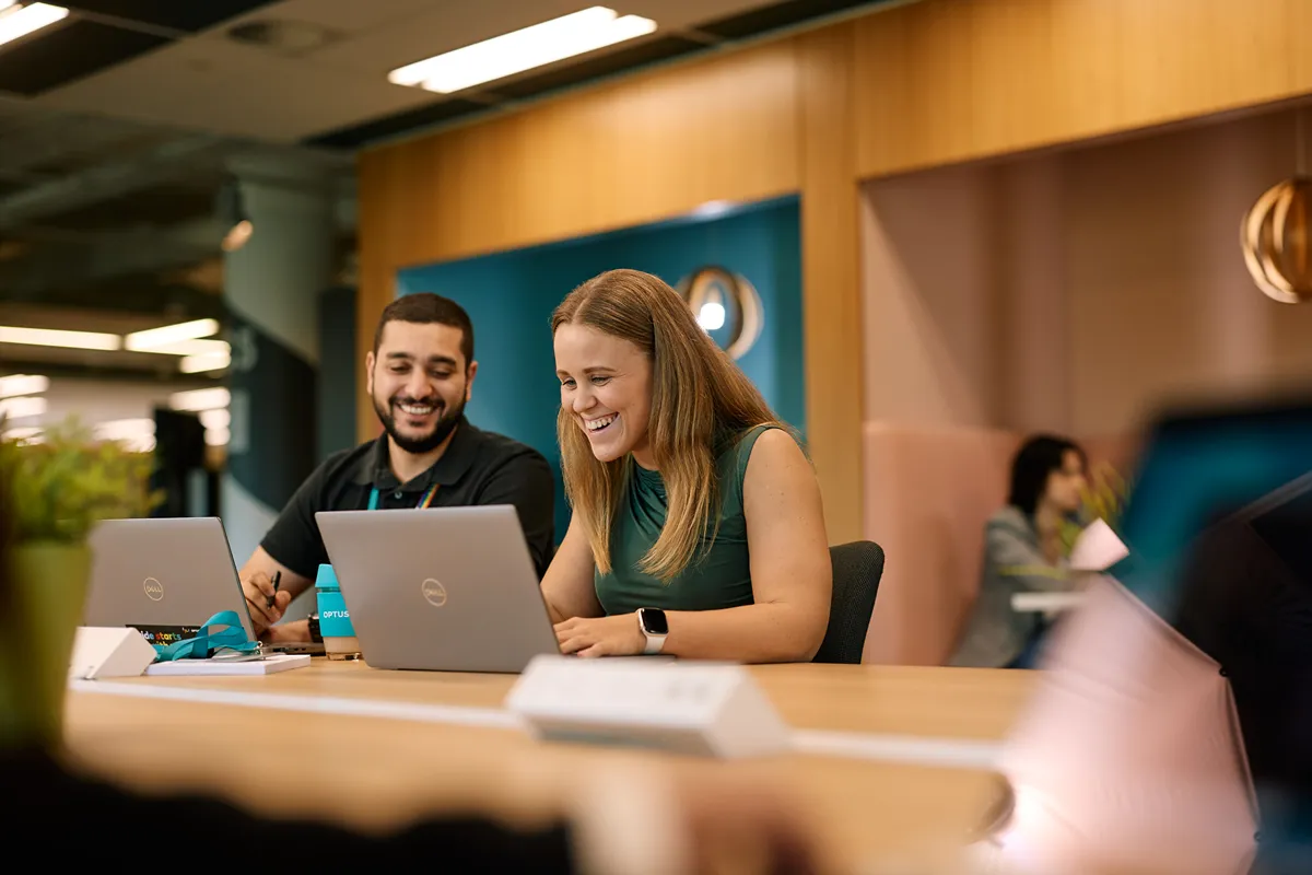 Three diverse people chatting outdoors under a modern canopy
