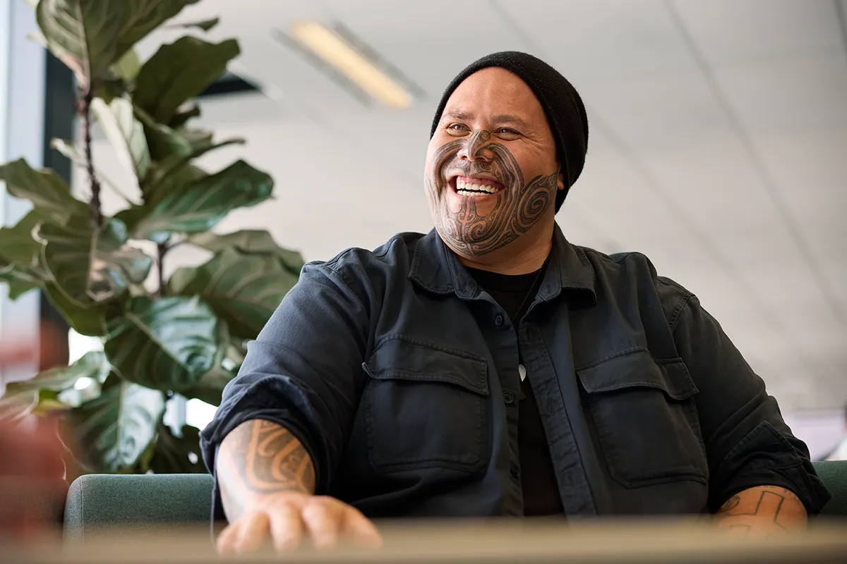 a man with tattoo on his face smiling