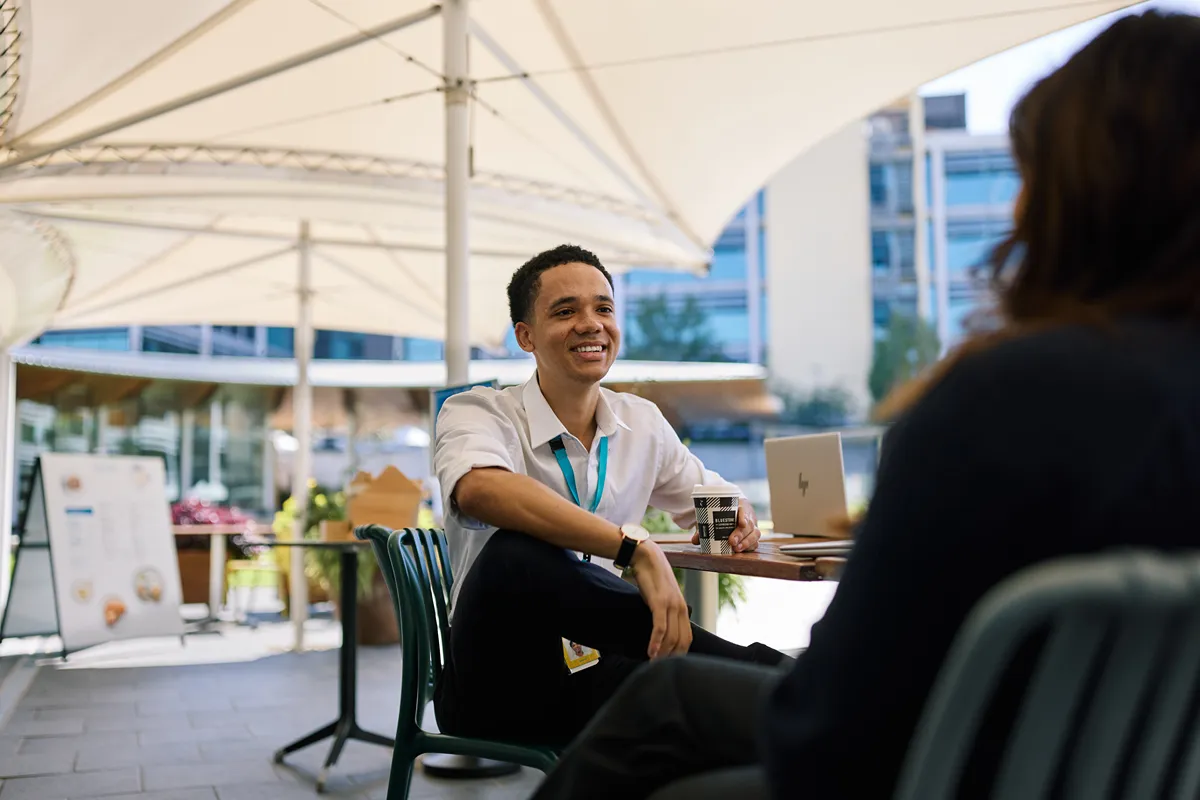 Smiling man sitting in a purple private booth in an office
