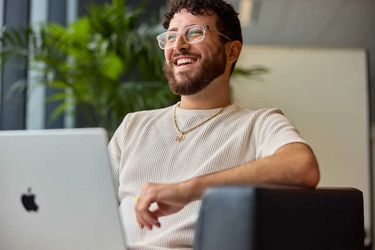 Two colleagues collaborating and smiling at a computer workstation