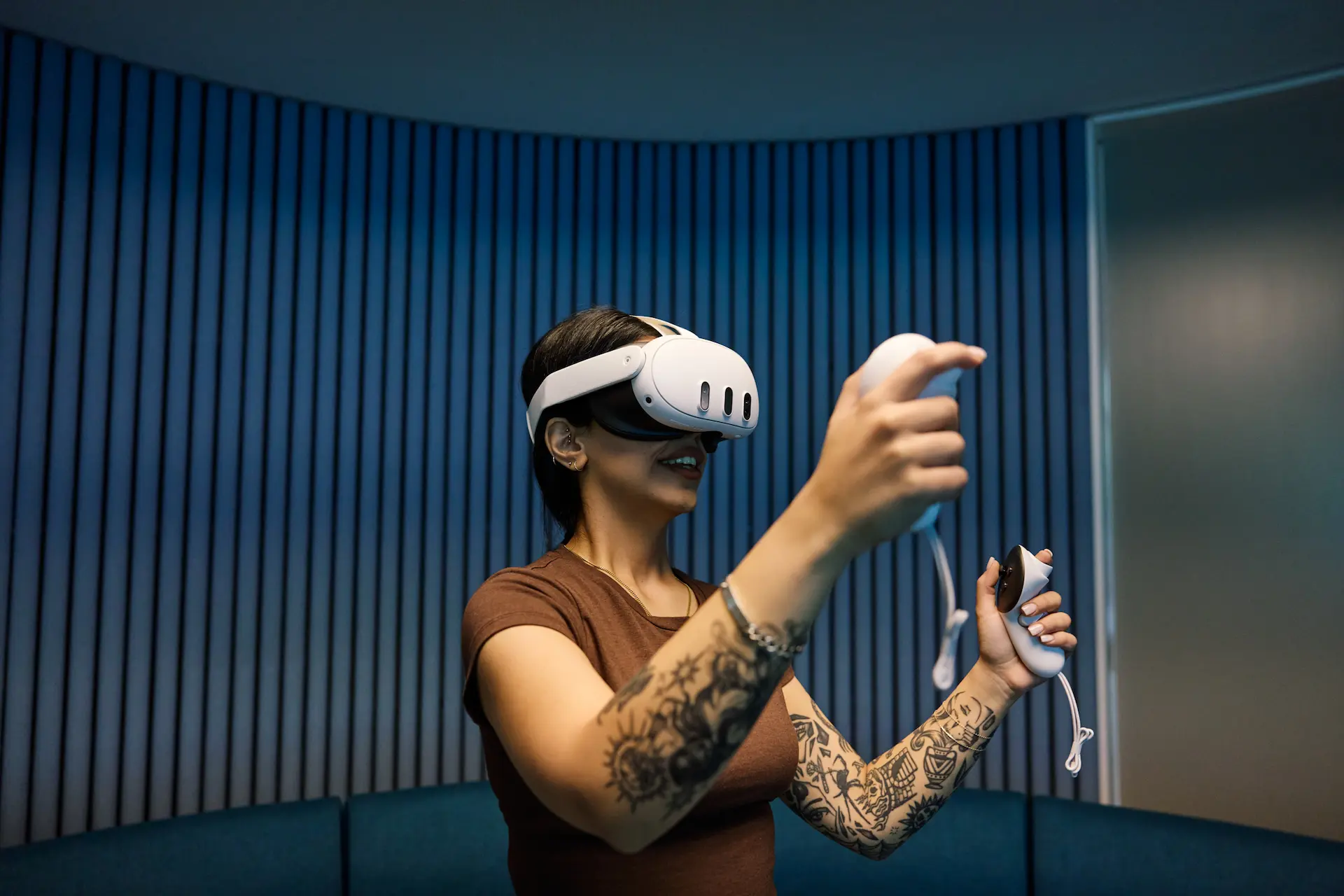 A woman wearing a VR headset holding joysticks