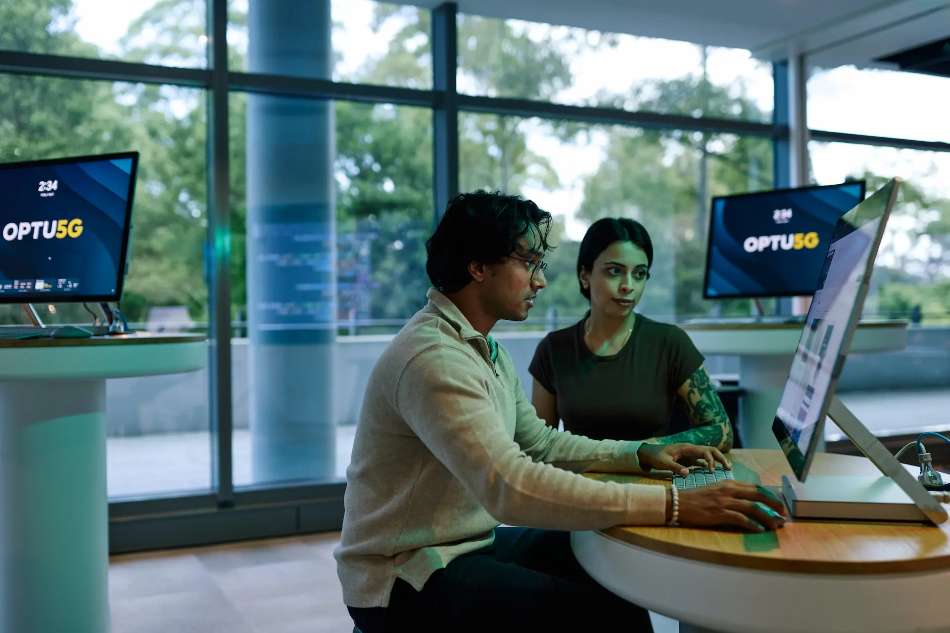 Two people sitting at a table looking at computer screen