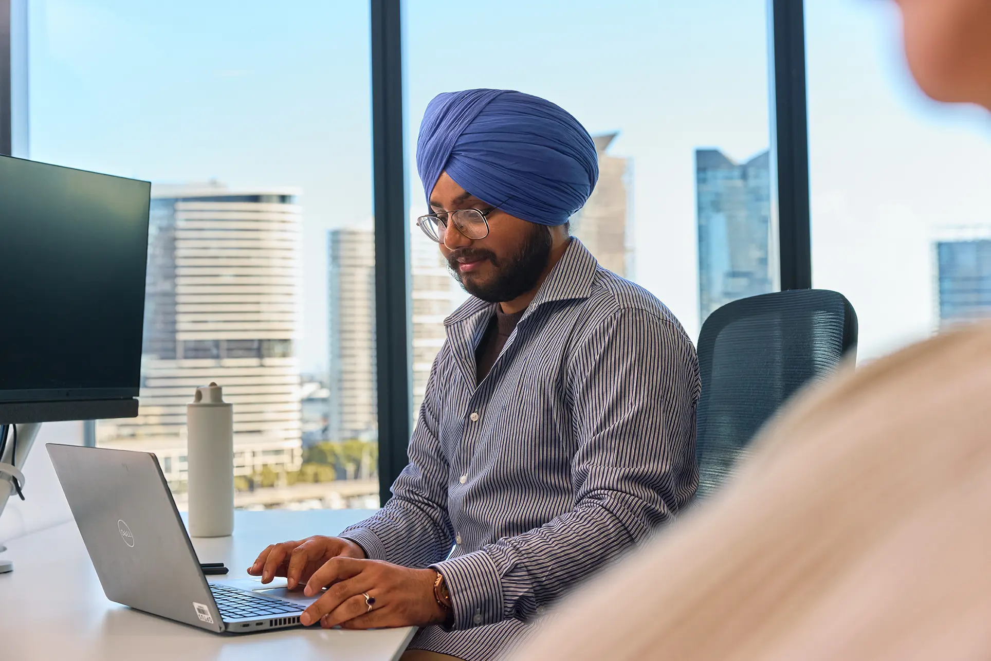 A man in an office working on a laptop