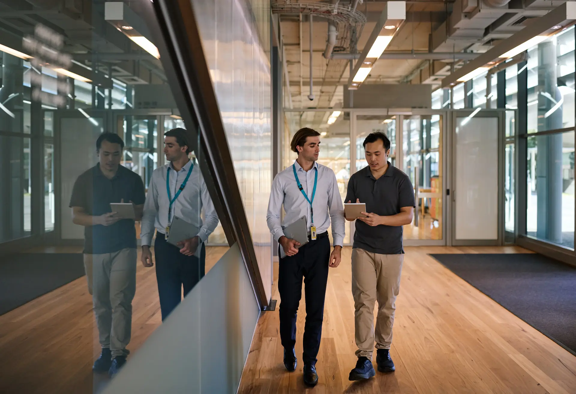 Two men walking in a hallway of a modern office building