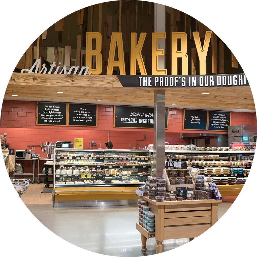 Artisan bakery with display cases filled with baked goods and signage promoting quality ingredients.