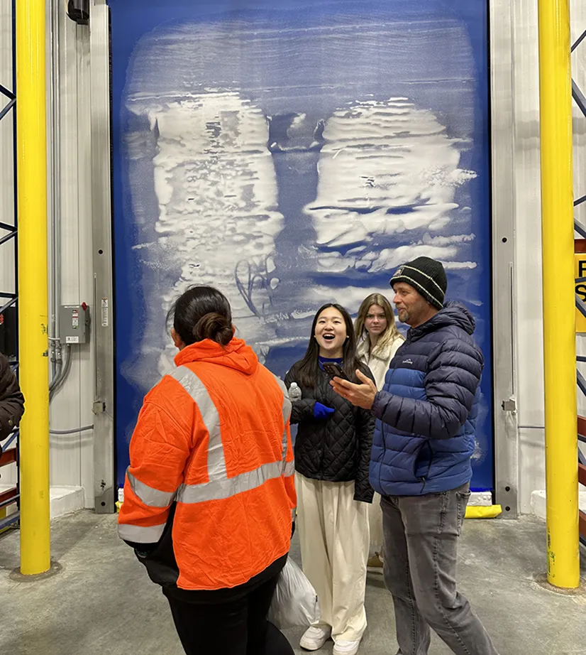 People standing in front of a large blue and white design on a wall, perhaps an opportunity or chance.