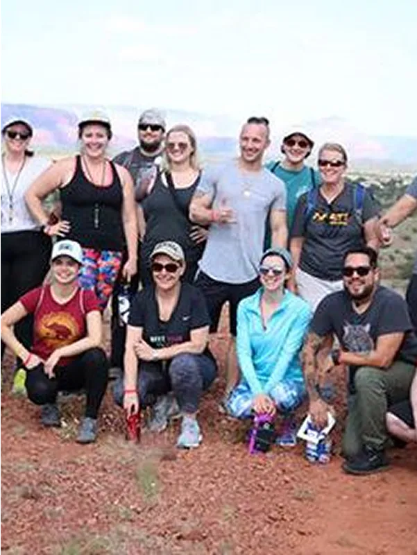 Group of people posing outdoors at a healthy retreat.
