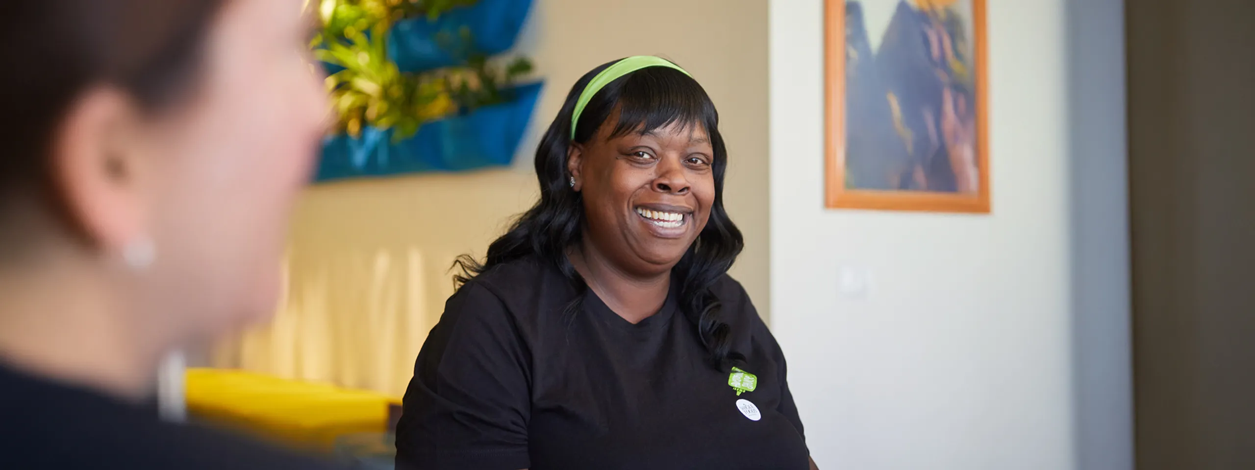 Woman smiling and looking at another person.