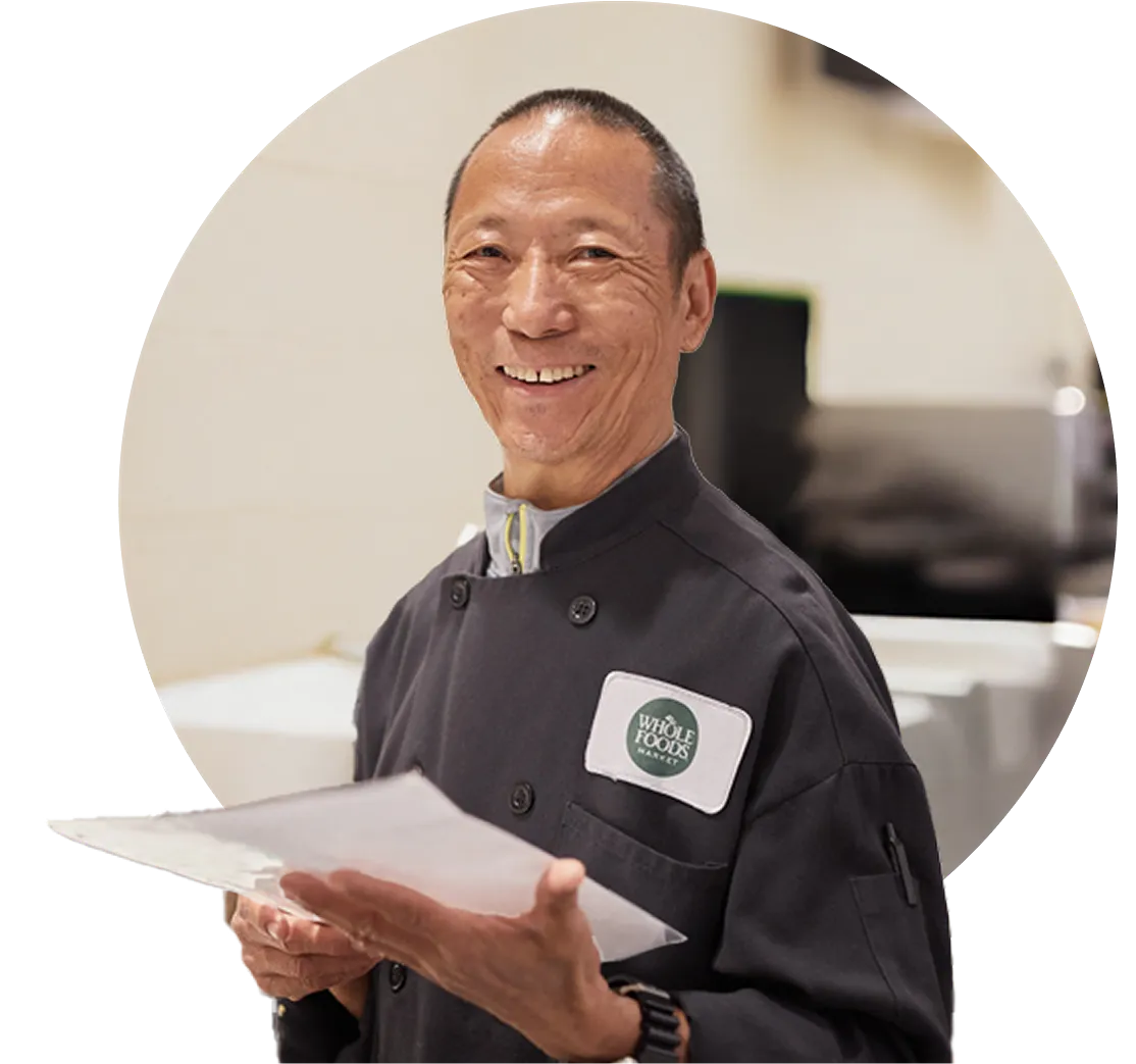 Smiling Whole Foods Market chef holding papers