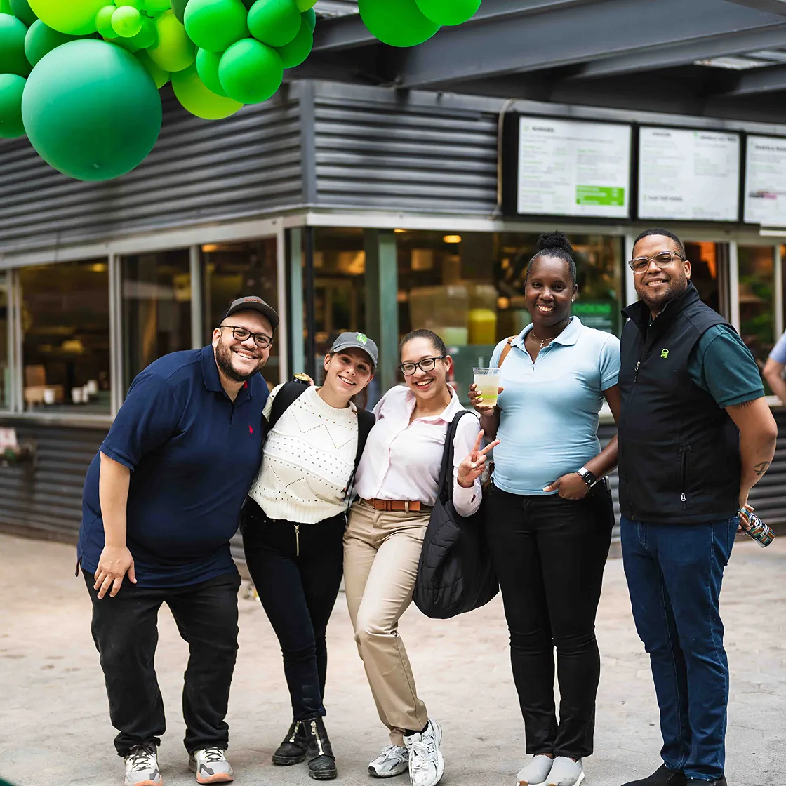 Group of smiling diverse colleagues standing together outside a restaurant