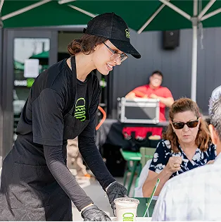 Shake Shack employee serving a customer outdoors