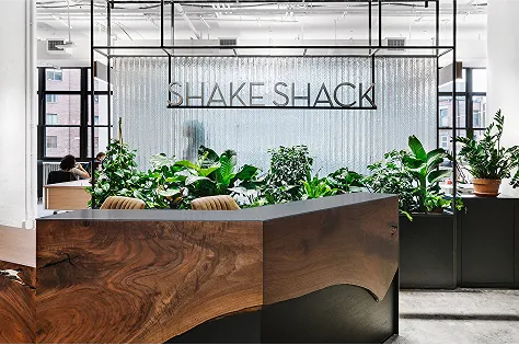 Shake Shack office reception area with a wood desk and plants
