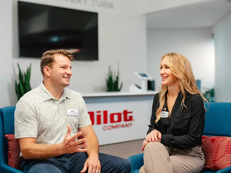Three diverse and smiling Pilot Flying J team members are posing together in a store.