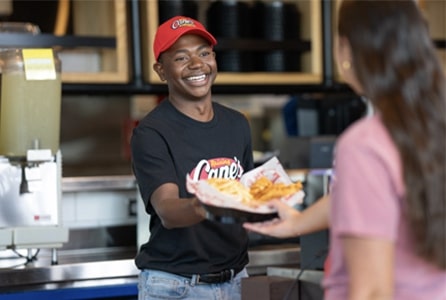 a male employee handing food to the other one