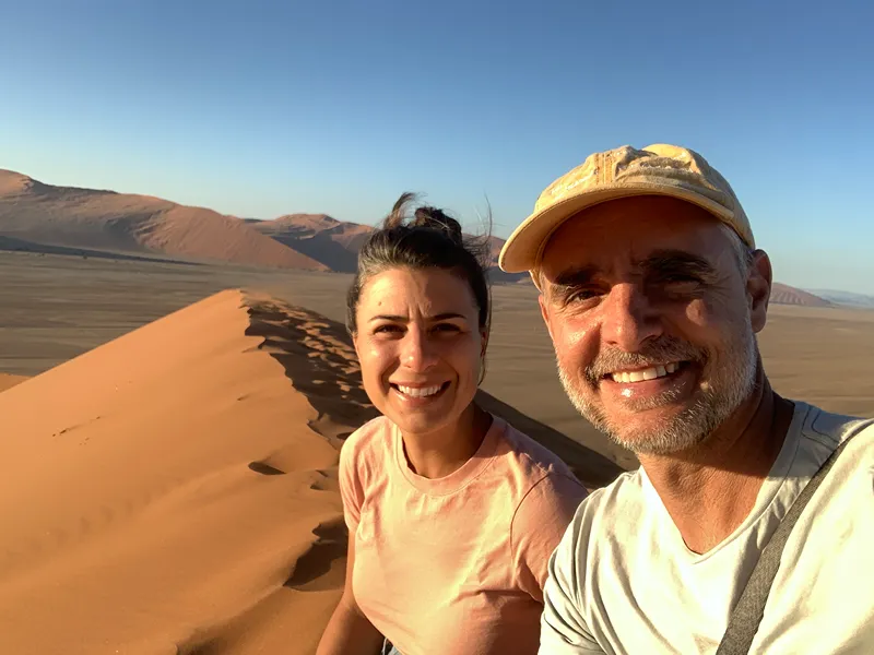2 people taking pictures in the desert
