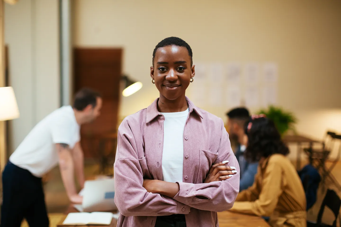 A woman is in a conference room with many other people.