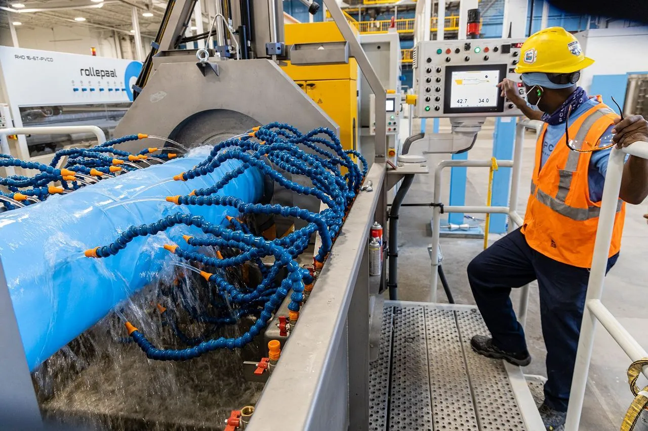 The worker is adjusting the machine.