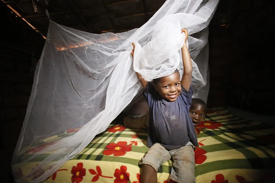 2 kids playing in their bed