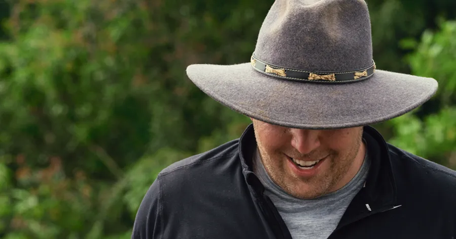 a man wearing a hat, looking down