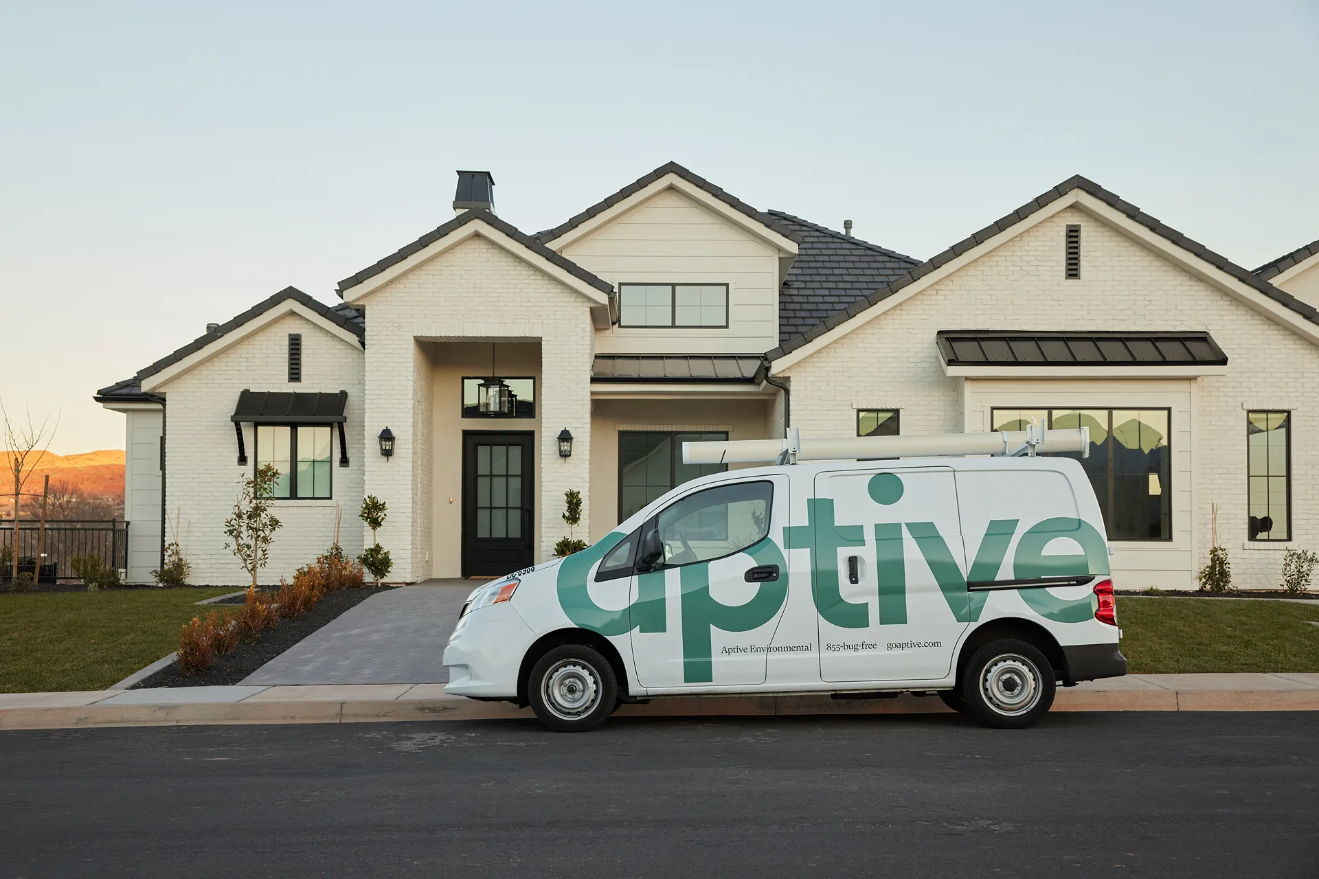 a van with Aptive logo parking in front of a house