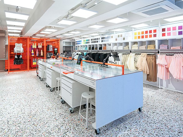 Interior of a modern retail store with workstations, colorful shelves, and organized clothing racks