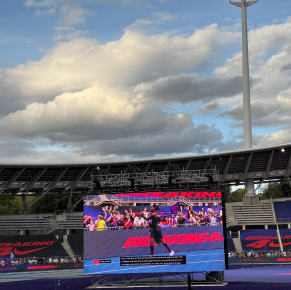 Stade avec un grand écran sous un ciel nuageux