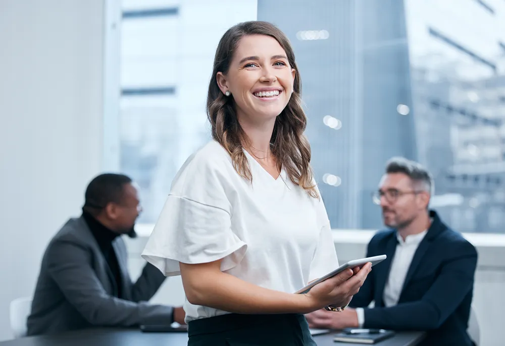 a woman holding a tablet and smiling