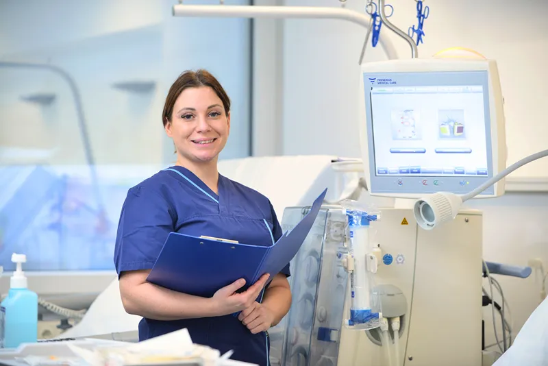 The nurse is holding a notebook in her hand.