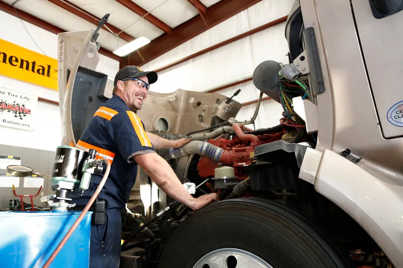 A technician at a Love's Truck Care & Speedco location performing maintenance on a truck.