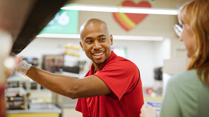 A man staff is saling food to a customer