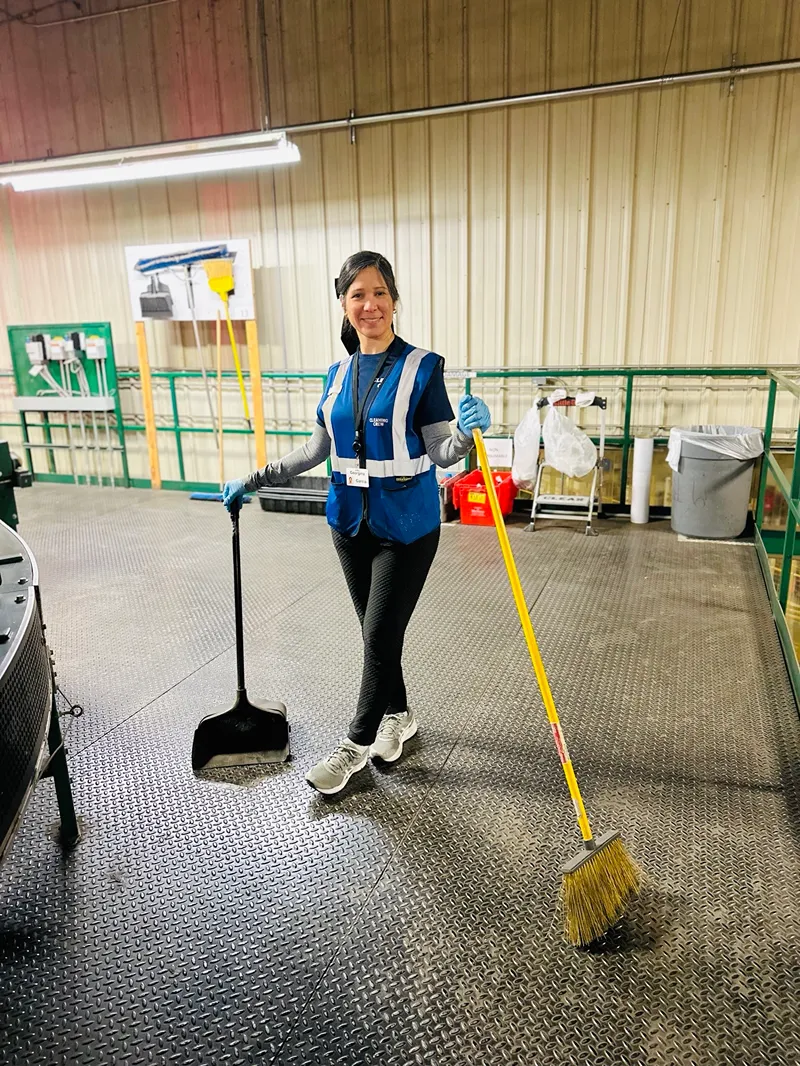 female worker holding cleaning tools