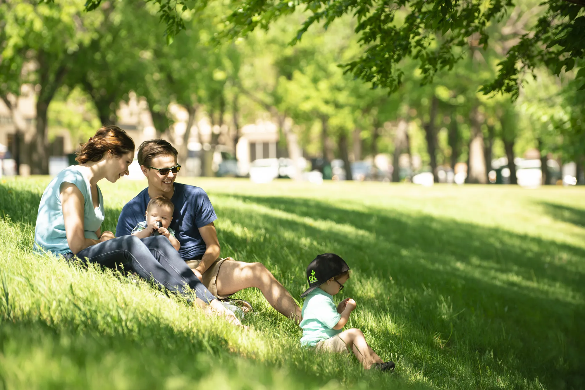 Une famille heureuse se relaxant ensemble sur la pelouse gazonnée d'un parc.