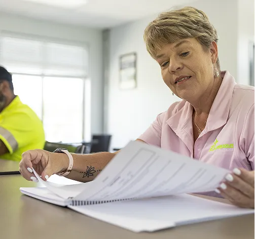 Une femme examinant des documents marketing lors d'une réunion.