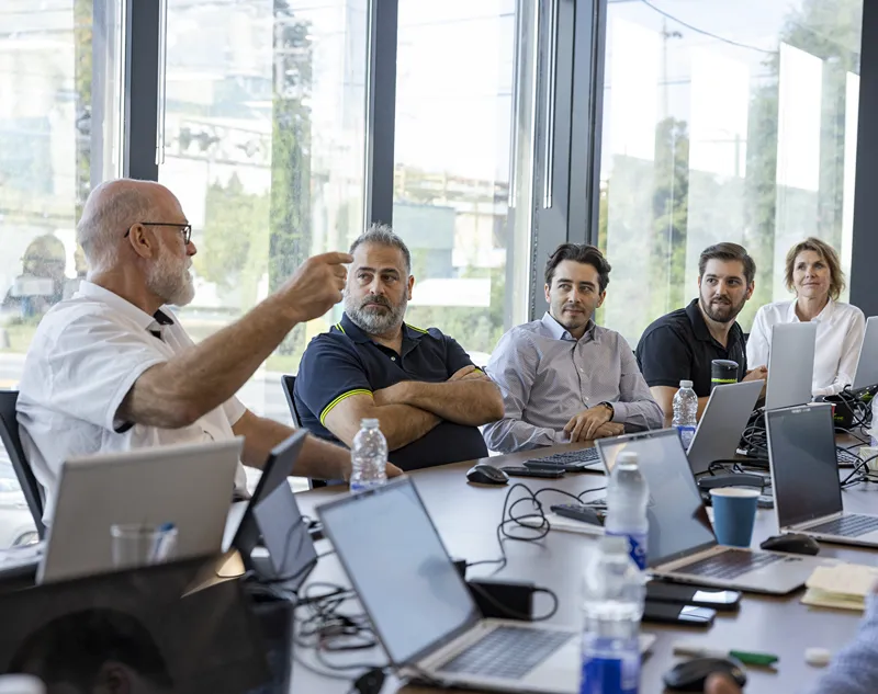 Les employés participant à une session de formation écoutent attentivement un présentateur, démontrant ainsi leur engagement envers leur entreprise.