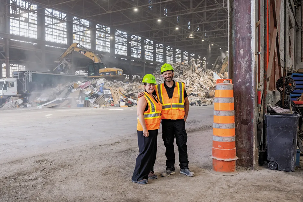 Équipe d'ouvriers de terrain en gilets et casques de sécurité dans une usine de recyclage.
