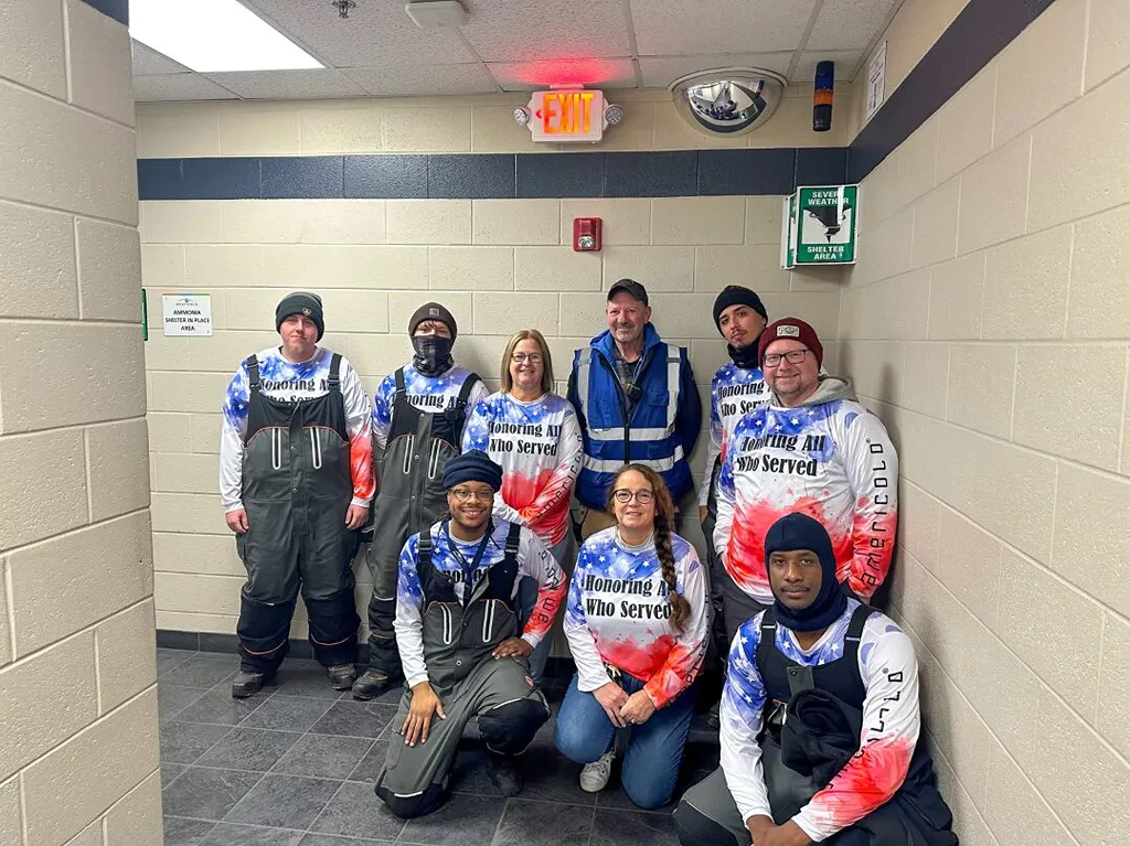 Group wearing patriotic gear posing in hallway near exit sign