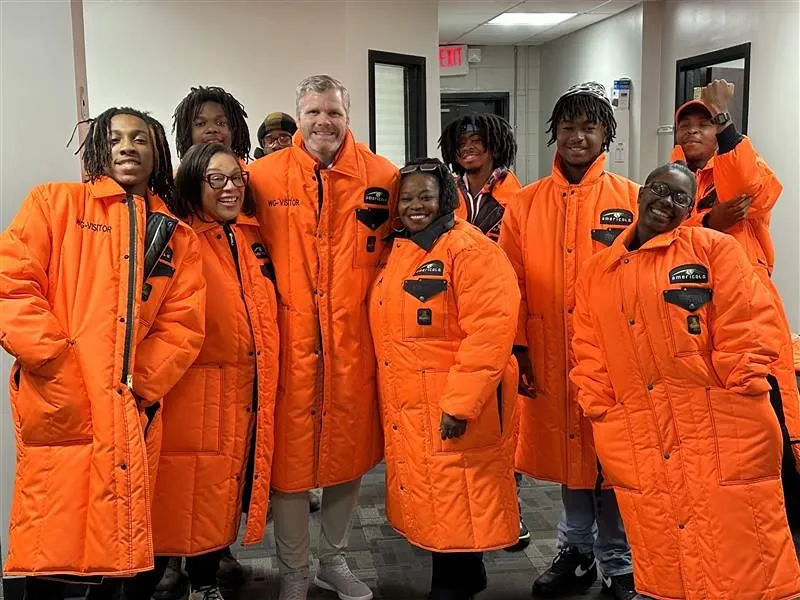 A diverse group of Americold employees volunteers at a community event, demonstrating the company"s commitment to community partnerships.