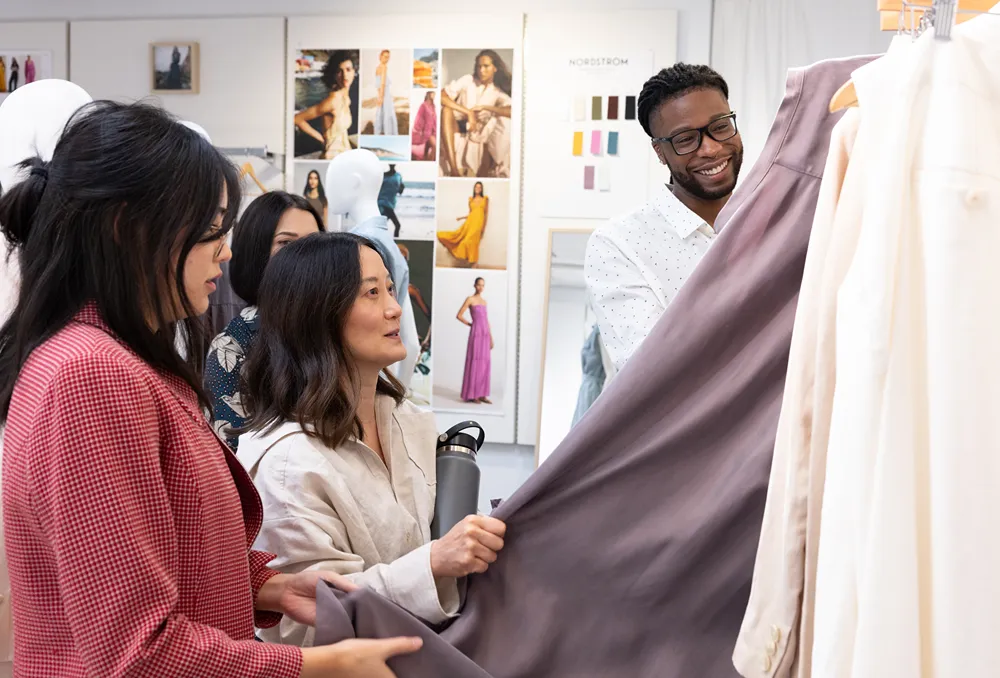 a group of people looking at clothes in a store