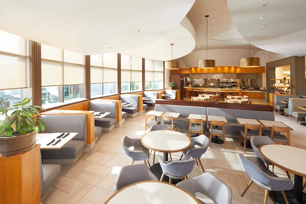 a restaurant with tables and chairs in front of large windows