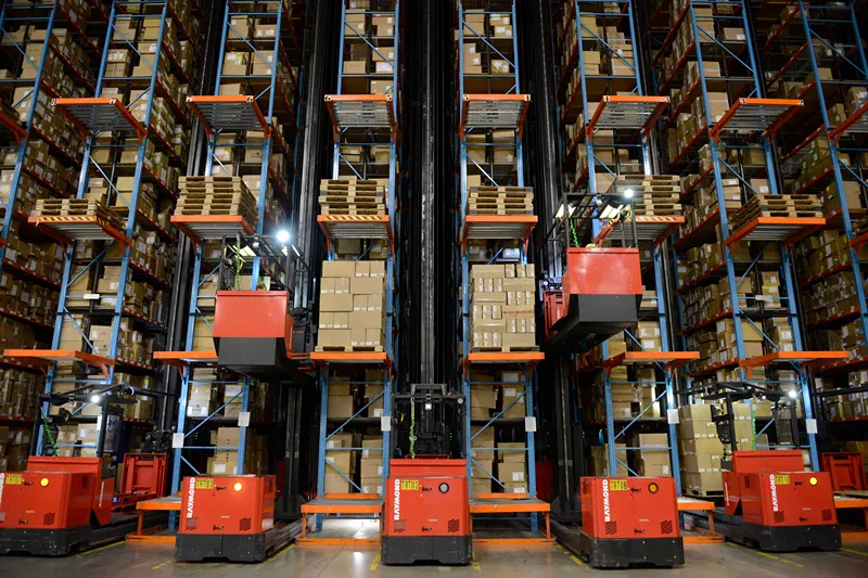 a large warehouse with many forklifts and boxes