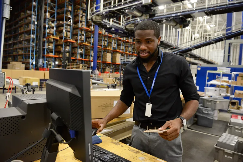 a man working on a computer in a warehouse